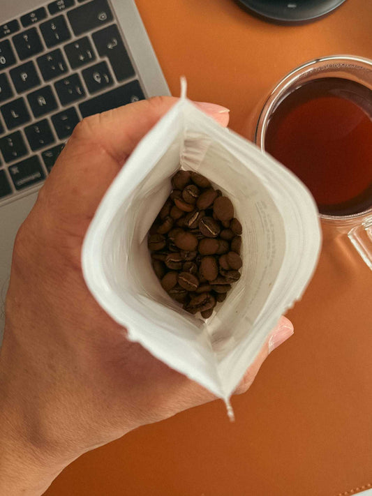 Fresh roasted whole bean coffee in a kraft bag with roast date label showing peak freshness window