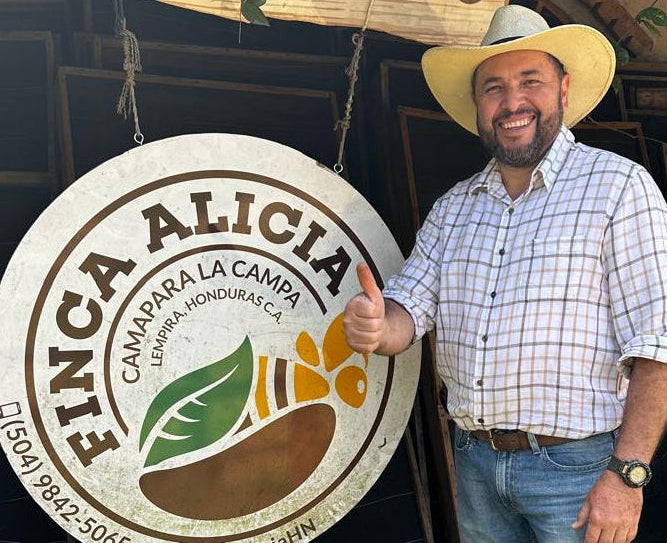 Jholman standing next to a 'Finca Alicia' sign
